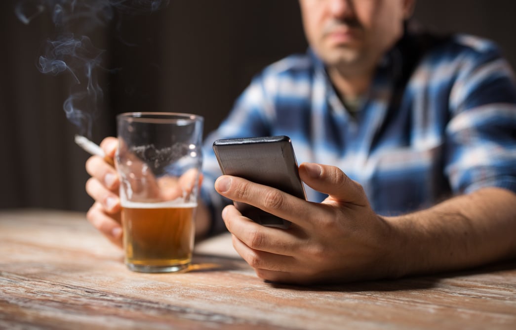 Man with Cellphone Drinking Alcohol and Smoking